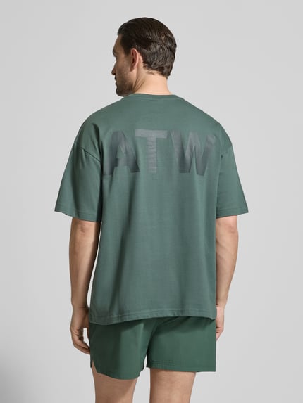 Męskimodel nosi Boxy Fit T-Shirt mit Rundhalsausschnitt von HALO z bawełny, w kolorze zielonym, pudełkowy krój, długość tyłu 71 cm, całkowity widok z tyłu.