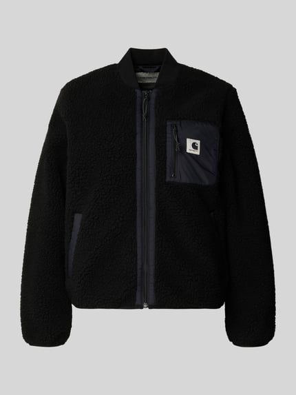 Produktfoto, Fleecejacke mit Zweiwege-Reißverschluss Modell 'Janet' von Carhartt Work In Progress, czarny kolor, tkanina typu teddy, krój regular fit, stójka, kieszenie z przodu, kieszeń na piersi, detal z logo, długość tyłu w rozmiarze S 80 cm, szerokość ramion w rozmiarze S 38 cm, szerokość w rozmiarze S 52 cm, długość rękawa w rozmiarze S 62 cm