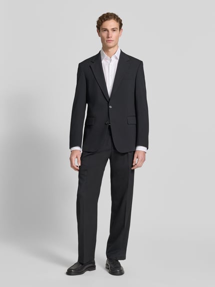 Männermodel trägt Regular Fit Anzugsakko mit Woll-Anteil Modell 'REECE' von Strellson, schwarz, Reverskragen, 2-Knopf, Ganzkörperansicht von vorne.