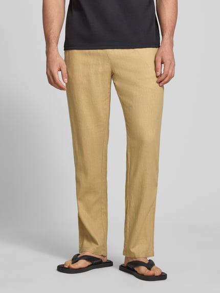 Męski model nosi Wide Fit Leinenhose mit Viskose-Anteil Modell 'Malvin' von Blend, beżowy len z wiskozą, elastyczny pas, kieszeń z tyłu, szerokość w rozmiarze M: 38 cm, długość nogawki: 76 cm, całkowity widok od przodu.