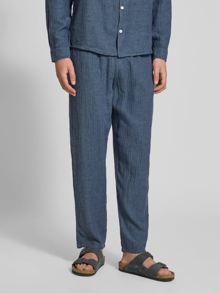 Männermodel trägt Hose aus Leinen-Baumwoll-Mix mit elastischem Bund von Redefined Rebel, Relaxed-Fit, Ganzkörperansicht von vorne.