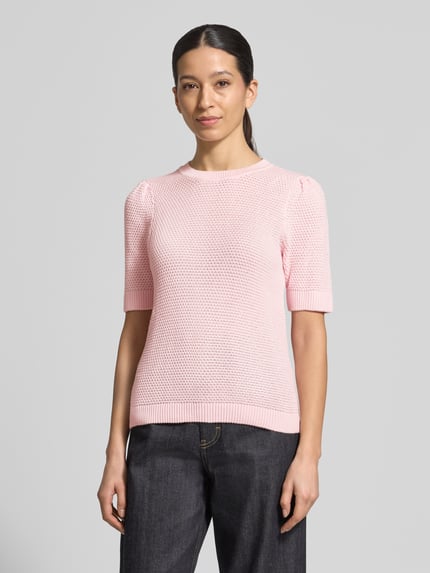 Frauenmodel trägt Slim Fit T-Shirt in Strick-Optik Modell 'Vidalo' von Vila aus reiner Baumwolle in zartem Rosa, Nahaufnahme Oberkörper.