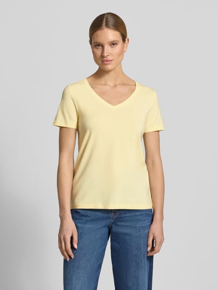 Modelka kobieca nosi Regular Fit T-Shirt aus Baumwoll-Mix von s.Oliver RED LABEL, efekt: jednolity kolor, dekolt w serek, krótki rękaw, wykończenie materiału: dżersej, mieszanka bawełny, jasny żółty, gładka tekstura, Ganzkörperansicht von vorne.
