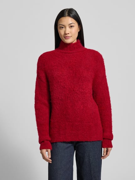 Frauenmodel trägt Strickpullover mit Stehkragen und überschnittenen Schultern von Milano Italy in Rot, Material-Mix mit Mohair-Anteil, Ganzkörperansicht von vorne
