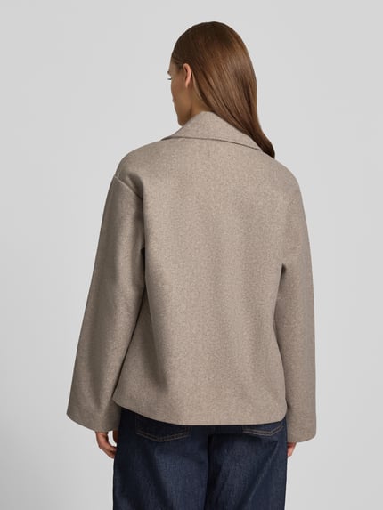 Frauenmodel trägt Regular Fit Mantel mit Reverskragen Modell 'NANCY' von ONLY in Unifarbe, Fleece, seitliche Eingrifftaschen, Ganzkörperansicht Rückansicht.