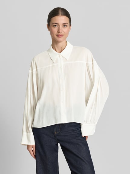 Frauenmodel trägt Relaxed Fit Bluse Modell 'SELENI' von Drykorn in Creme, Baumwoll-Viskose-Mix, Hemdblusenkragen, Knopfleiste, Ganzkörperansicht von vorne.