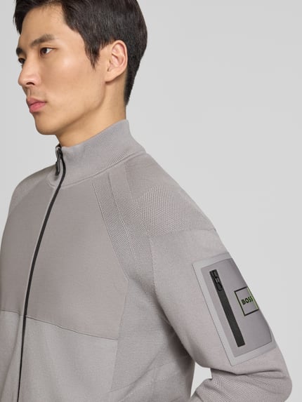 Männermodel trägt Regular Fit Sweatjacke aus Viskose-Mix Modell 'TOUR HY' von BOSS Green, unifarben, Stehkragen, Nahaufnahme Oberkörper.