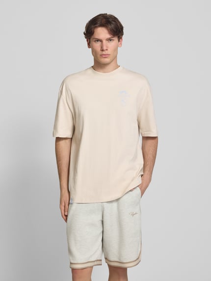 Männermodel trägt Oversized T-Shirt mit rückseitigem Print Modell 'Pedroche' von Pegador aus Reine Baumwolle, Logo-Motiv-Print, Ganzkörperansicht von vorne.