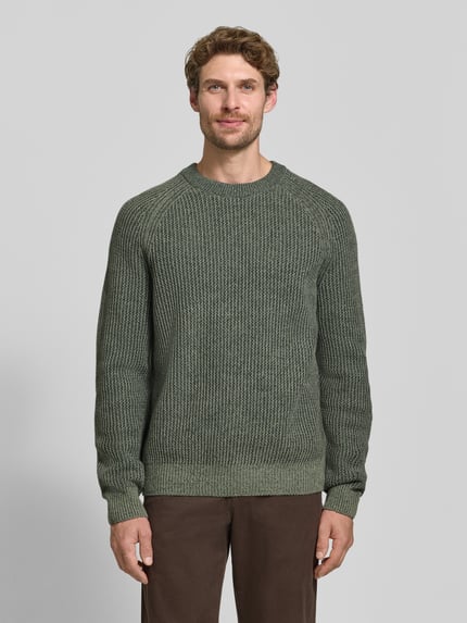 Männermodel trägt Regular Fit Pullover aus Woll-Mix Modell 'Kepler' von BOSS Orange in Olivgrün, grobe Strickstruktur, Ganzkörperansicht von vorne.