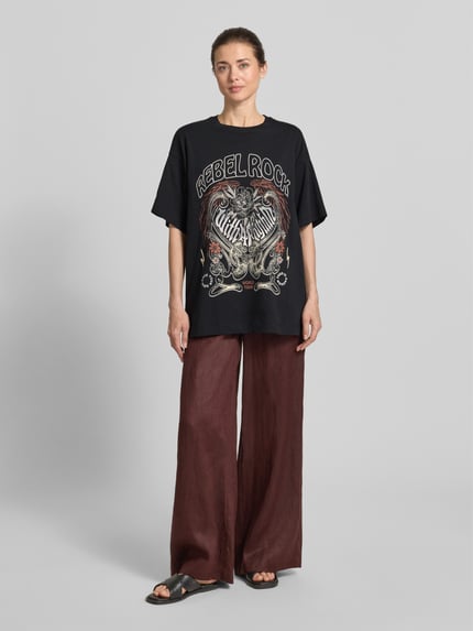 Modelka kobieca nosi damski t-shirt Oversized T-Shirt aus reiner Baumwolle Modell 'LILIE' von Vero Moda, jednokolorowy, bawełna, nadruk z motywem, krój oversized, krótki rękaw, widok z przodu typu całej sylwetki.
