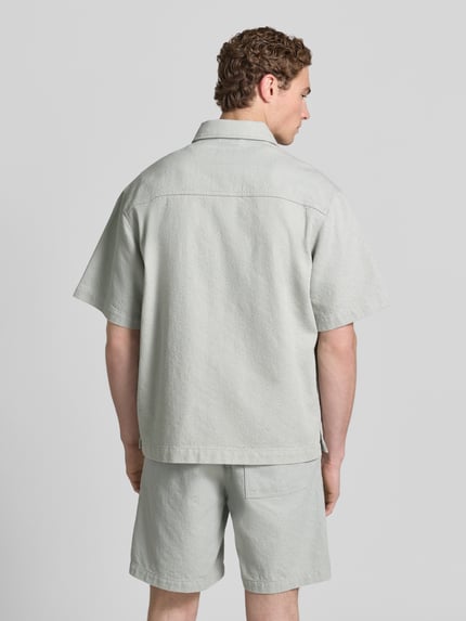 Männermodel trägt Regular Fit Freizeithemd aus Baumwoll-Mix Modell 'LAPOU' von BOSS Orange in Unifarbe mit kurzer Knopfleiste, Ganzkörperansicht Rückansicht.