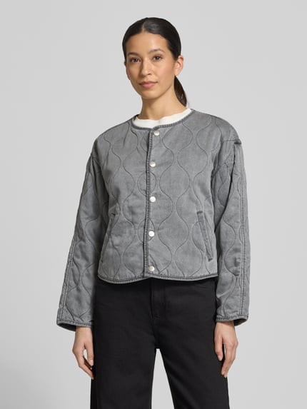Frauenmodel trägt Regular Fit Jacke aus reinem Lyocell Modell 'Alina' von CARS JEANS in Stepp-Optik mit Eingrifftaschen, Rundhalsausschnitt und durchgehender Knopfleiste, Farbe Grau, glatte Textur, Ganzkörperansicht von vorne. Rückenlänge 58 cm, Schulterbreite 49 cm, Brustweite 53 cm, Ärmellänge 53 cm bei Größe S.