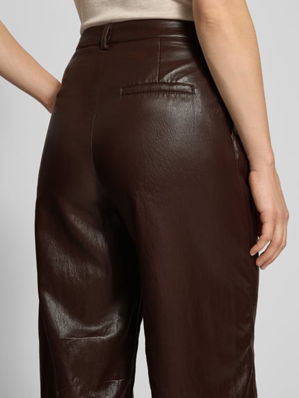 Frauenmodel trägt Wide Leg Kunstlederhose mit Gürtelschlaufen von Jake*s Casual in Dunkelbraun, glatte Textur, Nahaufnahme Rückansicht.
