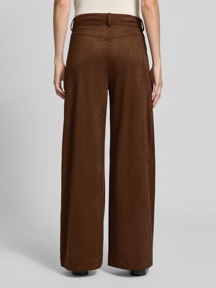 Frauenmodel trägt Wide Leg Kunstlederhose in Velours-Optik Modell 'C_Takora2' von BOSS Orange in Braun, Ganzkörperansicht Rückansicht. Damen Leder- / Kunstlederhose von BOSS.