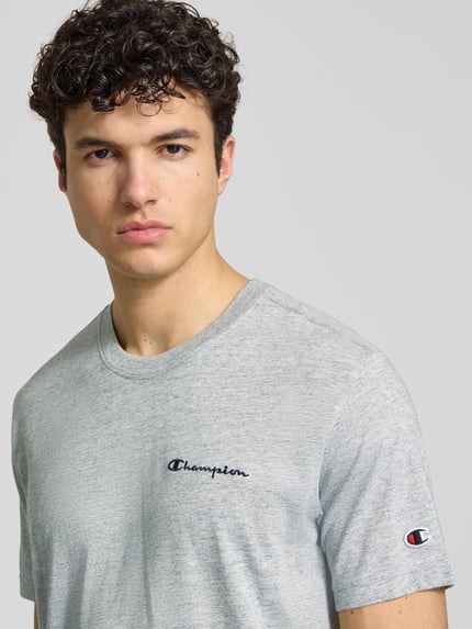 Männermodel trägt T-Shirt mit Logo-Stitchings Modell 'ICONS CONTRAST' von CHAMPION im Baumwoll-Mix, Modern Fit, Nahaufnahme Oberkörper.