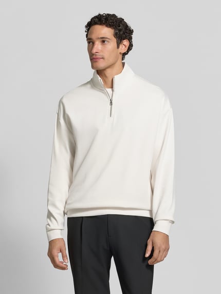 Męski model nosi Regular Fit Troyer aus Baumwoll-Mix Modell 'Dalizip' od HUGO w kolorze kremowym, proste linie, gładka tekstura, Ganzkörperansicht von vorne, Herren Troyer von HUGO.