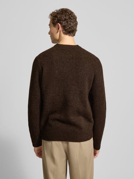 Männermodel trägt Strickpullover mit gerippten Abschlüssen Modell 'BLASIMON' von Jack & Jones Premium, braun, Ganzkörperansicht Rückansicht.
