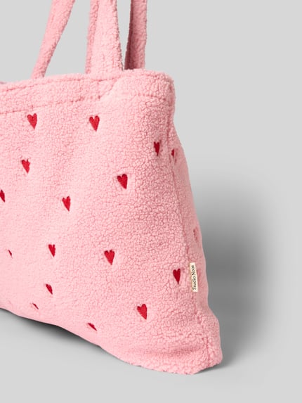 Produktfoto, Tote Bag mit Logo-Patch Modell 'Teddy' von Studio Noos, rosa Plüsch, rote Allover-Herz-Stickereien, sichtbarer Logo-Patch, strukturierte Oberfläche, Abmessungen 60x42x8 cm, Trageriemen 72 cm
