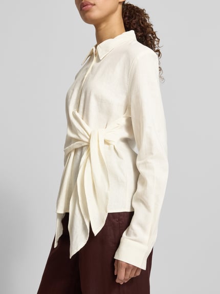Vrouwenmodel draagt Bluse aus Leinen-Viskose-Mix mit Knoten-Detail van GUIDO MARIA KRETSCHMER WOMAN, mix van linnen en viscose, getailleerd model, model 'MATHILDA', overhemdkraag, knoopsluiting, knoopdetail, ruglengte maat 36: 58 cm, mouwlengte maat 36: 64 cm, zijaanzicht van voren
