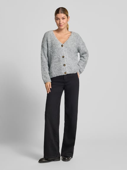 Frauenmodel trägt Cardigan mit V-Ausschnitt Modell 'So44fia' von ZABAIONE, meliertes Hellgrau, grobe Strickstruktur, Ganzkörperansicht von vorne.