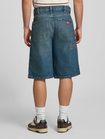 Männermodel trägt Loose Fit Bermudas mit Eingrifftaschen von Dickies aus Reine Baumwolle in Denim, Herren, Ganzkörperansicht Rückansicht.