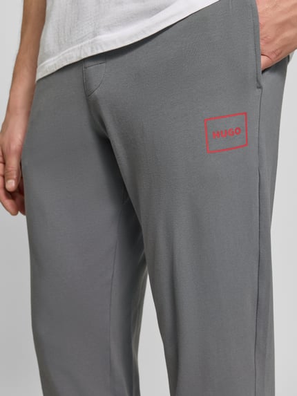 Männermodel draagt Regular Fit Sweathose aus katoenmix model 'Laze Pants CW' van HUGO, grijs, gladde stof, Heren Sweathose von HUGO, detailopname bovenbeen.