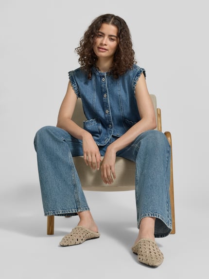 Frauenmodel trägt Flared Fit Jeans im 5-Pocket-Design von Jake*s Casual in mittlerem Blau mit Gürtelschlaufen und Knopf-Reißverschluss, Ganzkörperansicht von vorne.