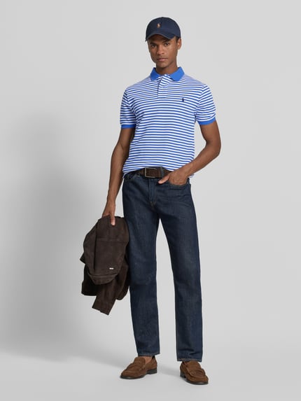 Männermodel trägt Slim Fit Poloshirt aus reiner Baumwolle Modell 'YD MESH STRIPE POLO' von Polo Ralph Lauren in Blau-Weiß, Ganzkörperansicht von vorne.