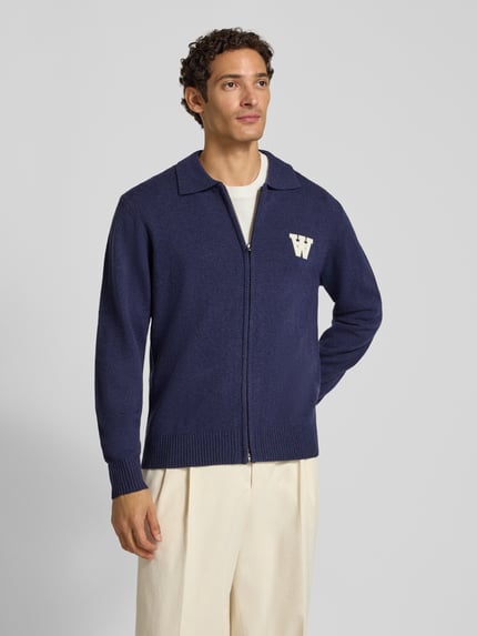Männermodel trägt Cardigan aus Wolle mit Zweiwege-Reißverschluss Modell 'Tay' von Wood Wood, dunkelblau, Regular Fit, Nahaufnahme Oberkörper.