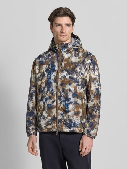 Männermodel trägt Blouson mit Kapuze und Zweiwege-Reißverschluss von ARMANI EXCHANGE, Allover-Look in Blau, Braun, Weiß, Ganzkörperansicht von vorne. Rückenlänge 71 cm, Schulterbreite 53 cm, Brustweite 64 cm, Ärmellänge 64 cm, Regular Fit, Reißverschlusstaschen, Tunnelzug.