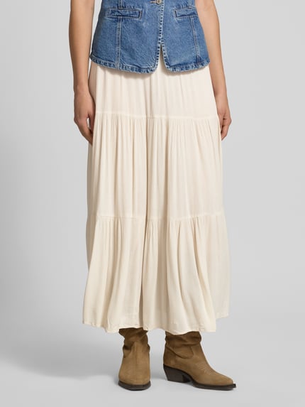 Vrouwenmodel draagt uitlopend damesmaxirok uit zuiver viscose, model 'MIKKA' van Only, effen kleuren, volants, kreuklook, maxilengte. Detailopname onderlichaam.