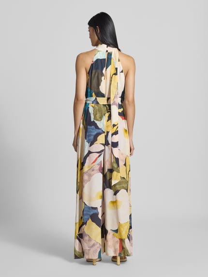 Frauenmodel trägt Regular Fit Jumpsuit aus reiner wiskoza Model 'Camea' von Ted Baker w kolorowy kwiatowy wzór, stójka, bez rękawów, taliowany krój, wycięcie w kształcie łezki, długość tyłu w rozmiarze 36: 38 cm, szerokość w rozmiarze 36: 49 cm, całkowita długość w rozmiarze 36: 146 cm, długość wewnętrzna nogawki w rozmiarze 36: 78 cm, widok całej sylwetki z tyłu.