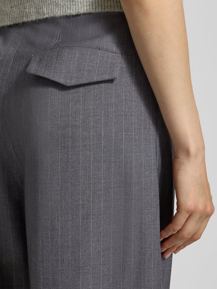 Kobiece model prezentuje Stoffhose mit Label-Detail Modell 'Leana' od OH APRIL, szary materiał z domieszką wiskozy, widok z tyłu zbliżenie na kieszeń.