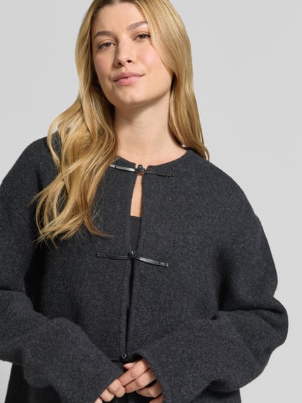 Frauenmodel trägt Strickjacke aus Wolle mit Knopfverschluss von Christian Berg Woman, dunkelgrau, Rundhalsausschnitt, Nahaufnahme Oberkörper.