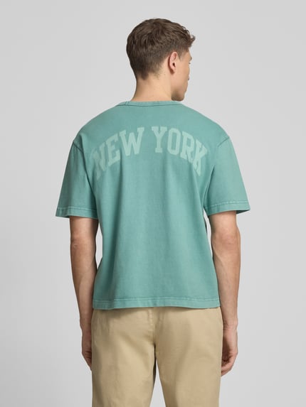 Männermodel trägt T-Shirt mit Logo und Rundhalsausschnitt von GAP, Herren T-Shirt aus Reine Baumwolle, Regular-Fit, Rückenlänge 61 cm, Ganzkörperansicht Rückansicht.