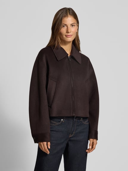 Frauenmodel trägt Jacke mit Eingrifftaschen Modell 'CANDYX' von MANGO, dunkelbraun, Reißverschluss, Material-Mix, Ganzkörperansicht von vorne.