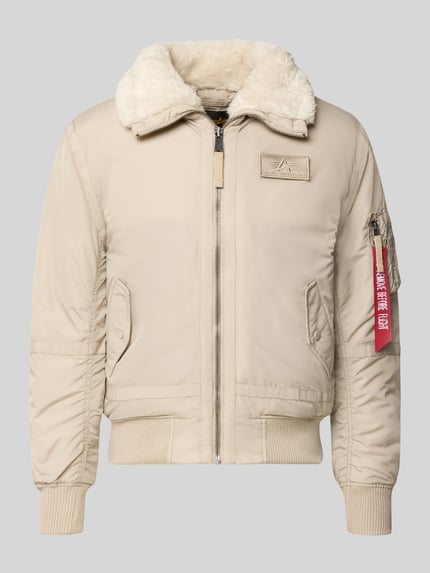 Produktfoto, Bomberjacke mit Label-Patch und Kentkragen von Alpha Industries in Beige mit Teddyfellkragen und roten Akzenten, glatte Textur