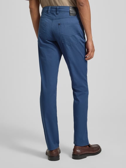 Mężczyzna nosi Hose im 5-Pocket-Design Modell 'CORDOBA' von bugatti, bawełniany materiał z domieszką stretchu, krój straight fit, kolor niebieski, zdjęcie całej sylwetki z tyłu.