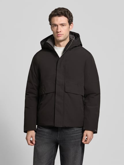 Männermodel trägt Jacke mit Kapuze und Pattentaschen Modell 'LAMOON' von JACK & JONES, dunkle Farbe, glatte Textur, Ganzkörperansicht von vorne, Regular Fit, verdeckter Reißverschluss, Kontext: Rückenlänge 72 cm, Schulterbreite 50 cm, Brustweite 60 cm, Ärmellänge 65 cm.