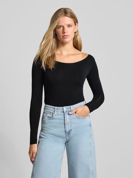 Frauenmodel trägt Slim Fit Langarmshirt U-Boot-Ausschnitt von REVIEW aus Lyocell-Mix mit Stretch, Schwarz, elastischer Bund, Ganzkörperansicht von vorne.