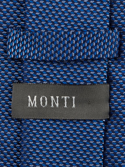 Produktfoto, Krawatte aus reiner Seide von Monti in Blau mit feiner Musterstruktur, Label-Detail sichtbar, klassische Passform, 7 cm breit.