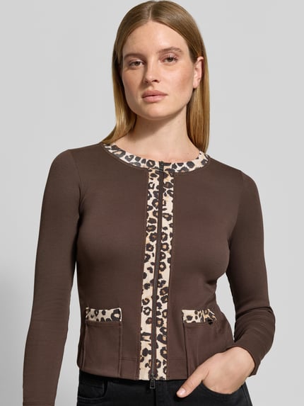Frauenmodel trägt Langarmshirt mit Zweiwege Reißverschluss von MARC CAIN, mehrfarbig mit Animal Print, elastische Jerseyverarbeitung, Nahaufnahme Oberkörper.