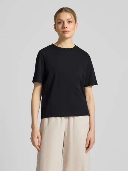 Frauenmodel trägt Regular Fit T-Shirt aus reiner Baumwolle Modell 'ASSIA' von Selected Femme, unifarben schwarz, Ganzkörperansicht von vorne.