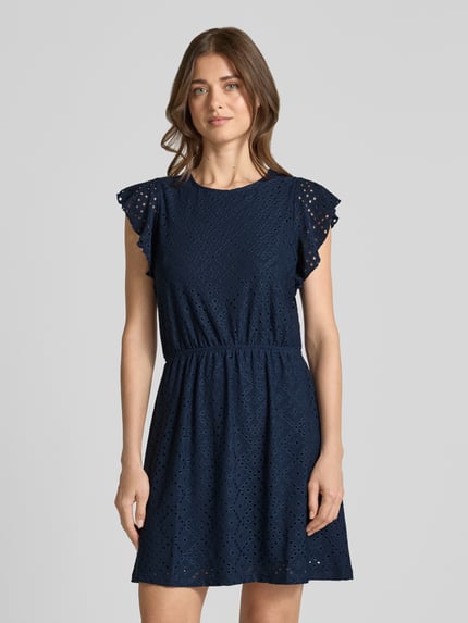 Vrouwenmodel draagt Tailliertes Sommerkleid mit Lochstickmuster Modell 'TASSA' van Vero Moda, effen kleuren, getailleerd, minilengte, ronde hals, jurk met korte mouwen, elastische tailleband, ajourpatroon, materiaalverwerking: ajourpatroon. Nahaufnahme bovenlichaam.