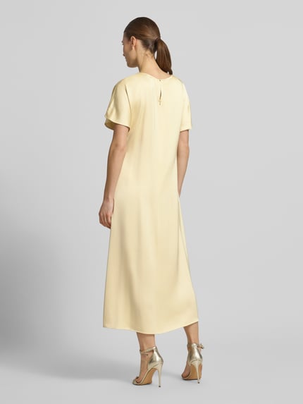Frauenmodel trägt Cocktailkleid mit Raffung und Kappärmeln von Christian Berg Cocktail in Gelb, Midilänge, Viskose-Mix, Rückansicht