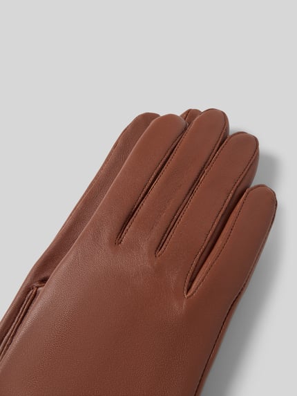 Produktfoto, Handschuhe aus echtem Leder mit Label-Detail von Roeckl, unifarbenes Design in Braun, glatte Textur, Detailaufnahme