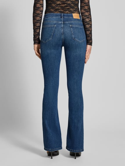 Vrouwenmodel draagt Flared Fit Jeans im 5-Pocket-Design van Review in blauwe katoenmix, met knoop- en ritssluiting, Ganzkörperansicht Rückansicht.