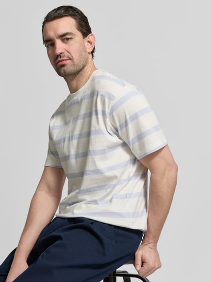 Männermodel trägt T-Shirt mit geripptem Rundhalsausschnitt von MCNEAL, weiß-hellblau gestreift, Regular Fit, Nahaufnahme Oberkörper.