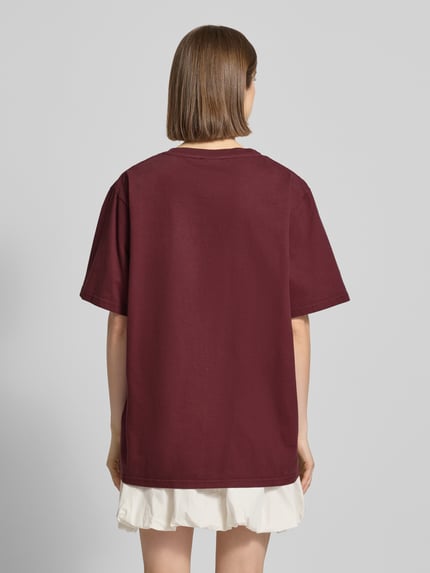 Frauenmodel trägt Oversized T-Shirt mit Statement-Print von OH APRIL, Reine Baumwolle, Oversized-Fit, Rückenlänge 70 cm, Ganzkörperansicht Rückansicht.