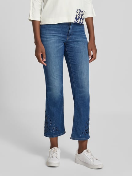 Frauenmodel trägt Feminine Fit Jeans mit Pailletten von Marc Cain in Blau, Baumwoll-Elasthan-Mix, Eingrifftaschen, Nahaufnahme Oberkörper.